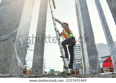 Side view of worker engineer in safety helmet climbing the ladder to get to the top . worker engineer metal roofing work for roof. 