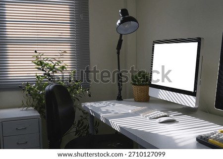 Side view workspace featuring a computer monitor, desk lamp, and office supply elements.