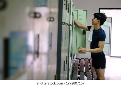 Side view a young Asian athletic man with a towel in the locker room after  exercising  with copy space for text or design. Concepts of health, sports and wellness. - Powered by Shutterstock