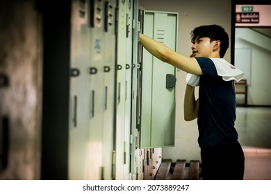 Side view a young Asian athletic man with a towel in the locker room after  exercising  with copy space for text or design. Concepts of health, sports and wellness. - Powered by Shutterstock