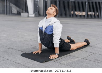 Side View Of Young Athlete Practicing Yoga, Lying In Cobra Pose, Doing Back Bend Stretching Exercise. Sportsman Warming Up Body, Working Out On Sport Mat, Training Outdoors