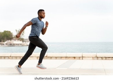 Side view of young athletic and fit african american sport man doing running workout at the beach. Male training hard and jogging. Healthy lifestyle concept  - Powered by Shutterstock