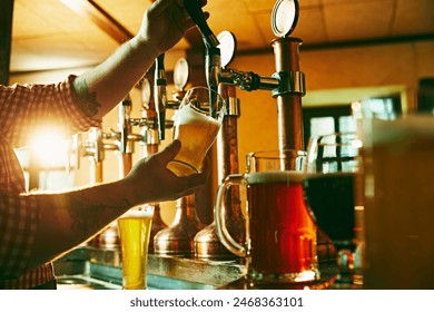 Side view of young bartender pouring beer while standing at the bar counter. Warm pub atmosphere. Concept of beer drink, alcohol, brewery, pub atmosphere, taste - Powered by Shutterstock