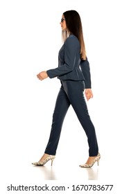 Side View Of Young Beautiful Business Woman In A Pants And Jacket Walking On White Background