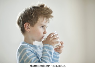 Side View Of A Young Boy Drinking Milk