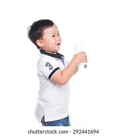 Side View Of A Young Boy Drinking Milk. Asian Kid Drinks A Glass Of Milk. Cute Boy With Milk Mustache Isolated On White