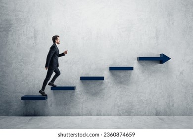 Side view of young businessman climbing blue arrow stairs to success on concrete wall background in interior. Financial growth, career development and forward concept