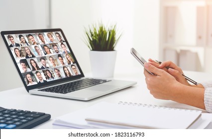 Side view of young businesswoman using smartphone during her video chat session with colleagues from home office. - Shutterstock ID 1823116793