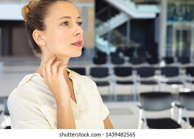 Side view of young Caucasian female executive looking away while standing in empty conference room - Shutterstock ID 1439482565