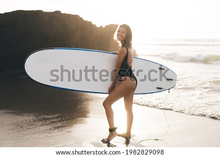 Similar – Young surfer woman with top and bikini holding surfboard