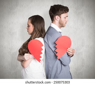 Side view of young couple holding broken heart against weathered surface
