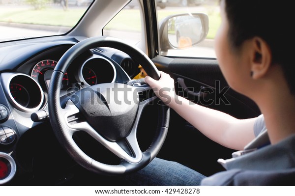 Side view of young driver in\
car