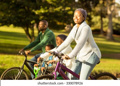 Side View Of A Young Family Doing A Bike Ride On An Autumns Day