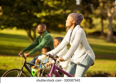 Side View Of A Young Family Doing A Bike Ride On An Autumns Day