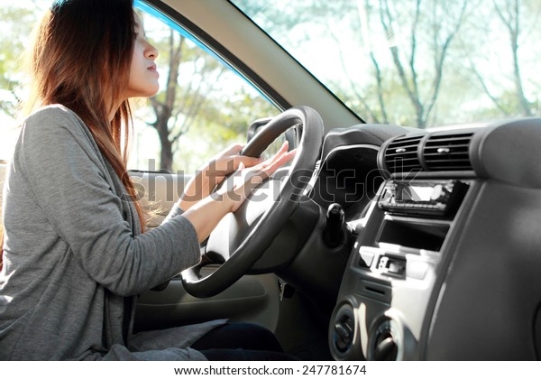 side view of young\
female driver use horn