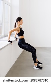 Side View Of Young An Fitness Woman In Sportswear Doing Deep Squat At Gym