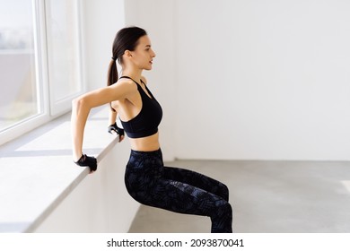 Side View Of Young An Fitness Woman In Sportswear Doing Deep Squat At Gym