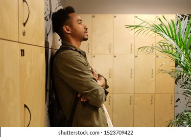 Side view of young handsome casual African American man thoughtfully standing in locker room - Powered by Shutterstock