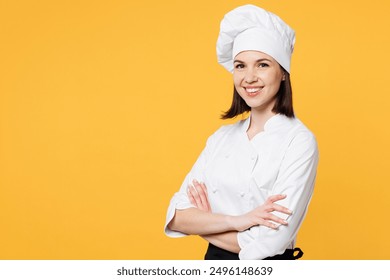 Side view young happy chef cook baker woman wear white shirt black apron uniform toque chefs hat hold hands crossed folded look camera isolated on plain yellow background studio. Cooking food concept - Powered by Shutterstock