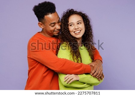 Side view young happy fun couple two friends family man woman of African American ethnicity wearing casual clothes together husband hug smiling wife isolated on pastel plain light purple background
