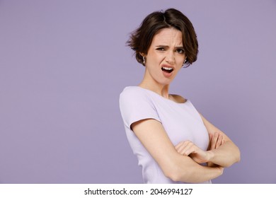 Side view young indignant frowning sad woman 20s with bob haircut wearing white t-shirt hold hands crossed folded scream isolated on pastel purple background studio portrait. People lifestyle concept.