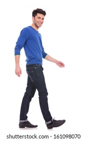 Side View Of A Young Man Laughing And Walking While Looking At The Camera, Full Body Picture