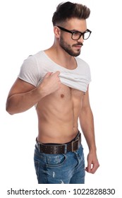 Side View Of A Young Man Pulling Up His Shirt On White Background