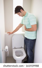 Side View Of A Young Man With Stomach Sickness About To Vomit Into The Toilet