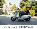 Side view of young man working as courier riding on motorcycle