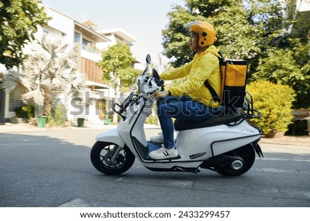 Side view of young man working as courier riding on motorcycle