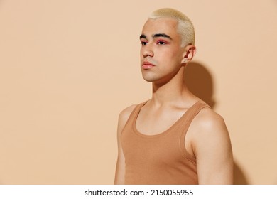 Side View Young Minded Serious Blond Latin Hispanic Gay Man 20s With Make Up In Beige Tank Shirt Looking Aside Isolated On Plain Light Ocher Background Studio Portrait People Lgbt Lifestyle Concept