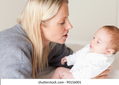 Side View Of Young Mother Laying Down Her Newborn