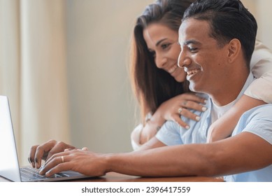 Side view of young people using laptop at home with happiness. Boy and girl living together and working on a notebook computer enjoying internet wireless connection and technology. Smart working - Shutterstock ID 2396417559