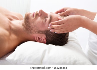 Side View Of Young Relaxed Man Getting Scalp Massage