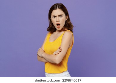 Side view young sad angry indignant woman 20s she wear yellow tank shirt hold hands crossed folded look camera isolated on plain pastel light purple background studio portrait People lifestyle concept - Shutterstock ID 2298940517