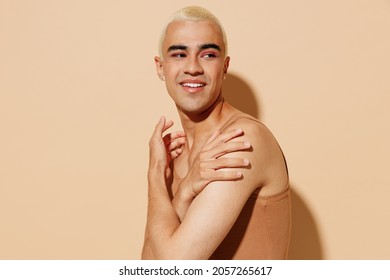 Side View Young Smiling Fun Blond Latin Hispanic Gay Man With Make Up In Beige Tank Shirt Hug Himself Look Aside Isolated On Plain Light Ocher Background Studio Portrait People Lgbt Lifestyle Concept