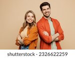 Side view young smiling happy fun cool couple two friends family man woman wear casual clothes hold hands crossed folded together isolated on pastel plain light beige color background studio portrait