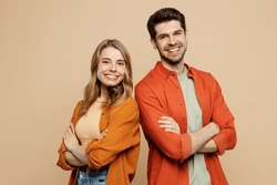 Side View Young Smiling Happy Fun Cool Couple Two Friends Family Man Woman Wear Casual Clothes Hold Hands Crossed Folded Together Isolated On Pastel Plain Light Beige Color Background Studio Portrait