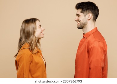 Side view young smiling happy fun cool couple two friends family man woman wearing casual clothes looking to each other together isolated on pastel plain light beige color background studio portrait - Powered by Shutterstock