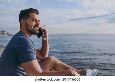 Side view young strong sporty fit fun sportsman man 20s in sports clothes shorts warm up train talk by mobile cell phone at sunrise sun over sea beach outdoor on pier seaside in summer day morning. - Powered by Shutterstock