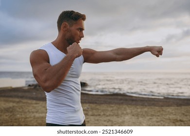 Side view young strong sporty athletic toned fit sportsman man wear sports clothes boxing clench fists warm up training at sunrise sun dawn over sea beach outdoor on pier seaside in summer day morning - Powered by Shutterstock