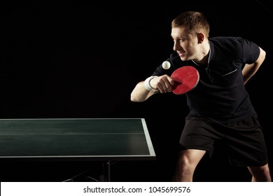 Side View Of Young Tennis Player Practicing In Table Tennis Isolated On Black