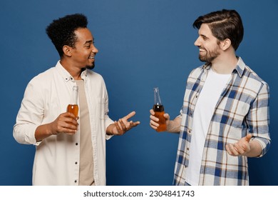 Side view young two friend men wear white casual shirts together talk speak spent time in bar hold bottle of beer drink alcohol isolated plain dark royal navy blue background People lifestyle concept - Powered by Shutterstock