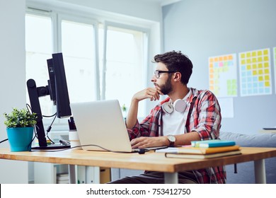 Side View Of Young Web Developer Looking At Screen And Thinking About Work Project