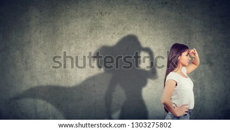 Side view of a young woman imagining to be a super hero looking aspired.