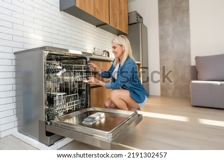 side view of young woman in kitchen doing housework