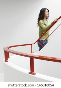 Side View Of A Young Woman Walking Up Stairs Indoors