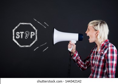 Side View Of A Young Woman Yelling Into The Megaphone Against Black Background