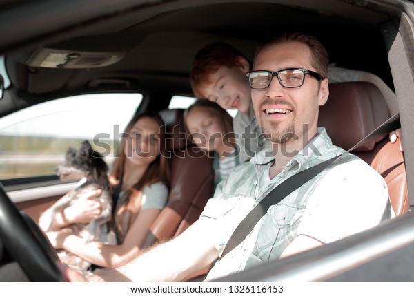 side view.happy\
father driving a family\
car