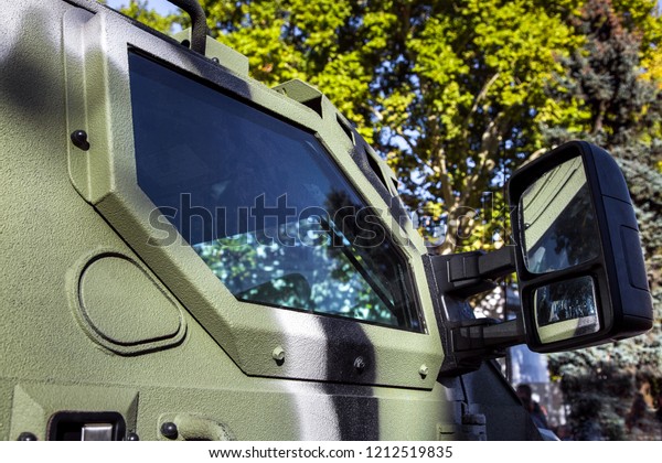 Side window of\
an armored military truck with a rearview mirror and a hatch for\
firing from a military\
vehicle.